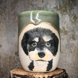 Handgetöpferter Becher mit dem Portrait eines Pudels und dunkelgrüner Glasur